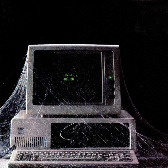 An old IBM computer covered in spiderwebs, and whose screen says R.I.P 1981-1983