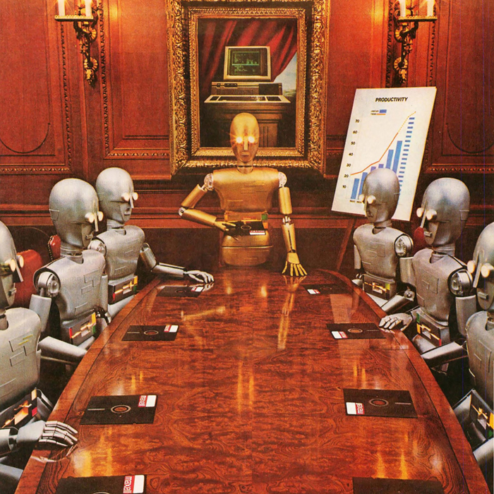 A golden robot oversees silver robots at a conference table while presenting a graph that shows productivity going up. Each robot has a floppy disk in front of it, and in the mirror behind the golden robot, a computer display is visible