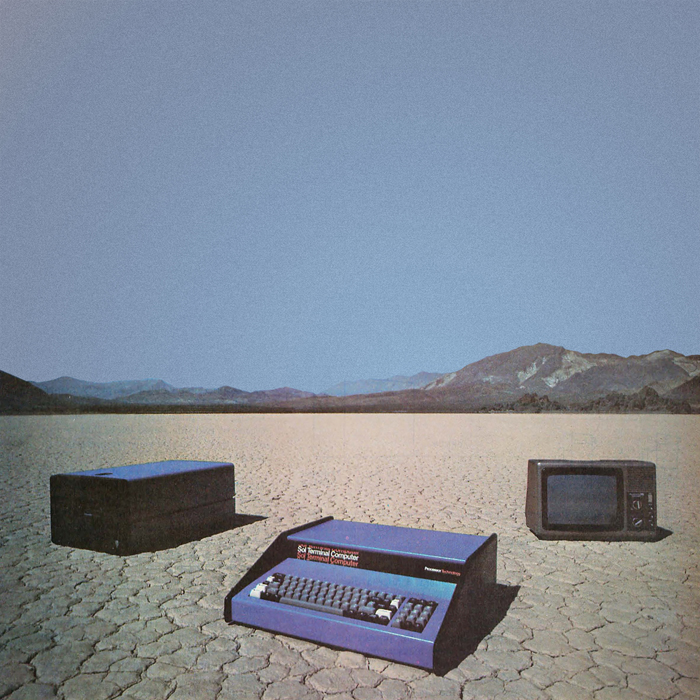 A box, an old computer, and a TV monitor in the desert