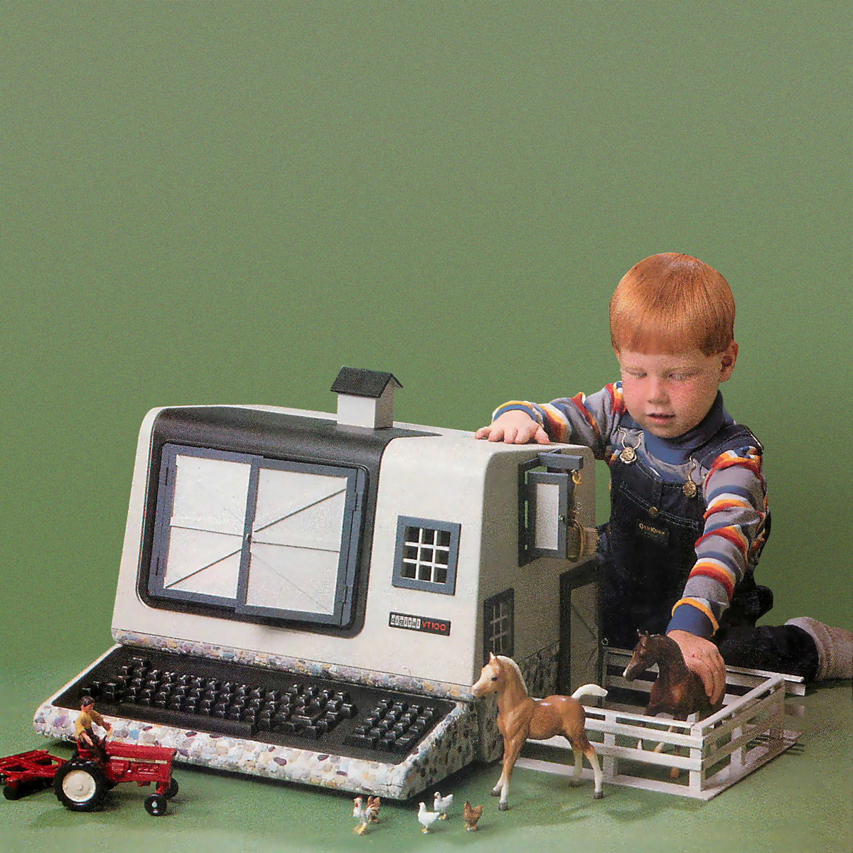 a toddler playing with toy horses in a toy barn that looks like a computer