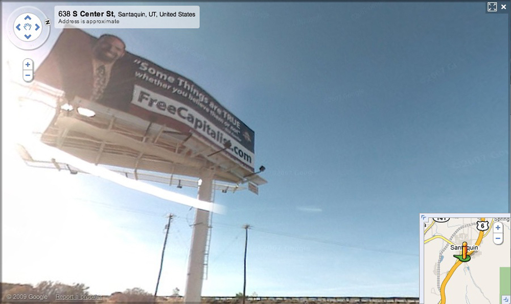 Street View of a billboard with a businessman smiling and large text that says FreeCapitalist.com