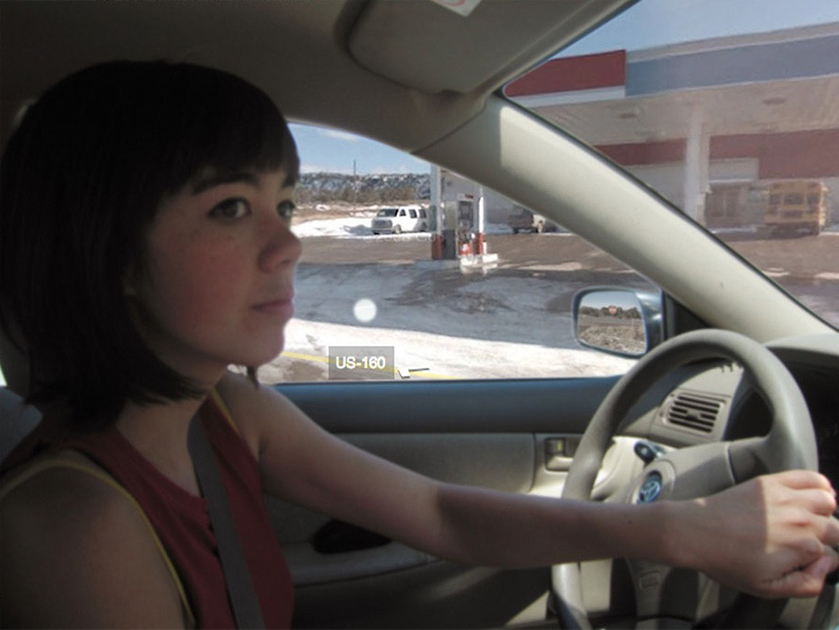 Jenny Odell inside her car turning right, with Street View of a gas station photoshopped outside the car windows