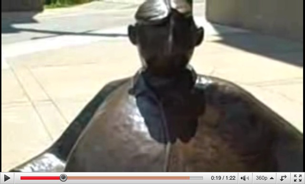A YouTube video showing the same statue of the man on a bench, but closer up and in more detail